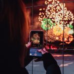 woman taking a picture of fireworks during night